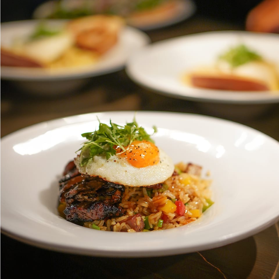 La Condesa Eatery's fusion dish: fried rice with meat, topped with a fried egg and greens.