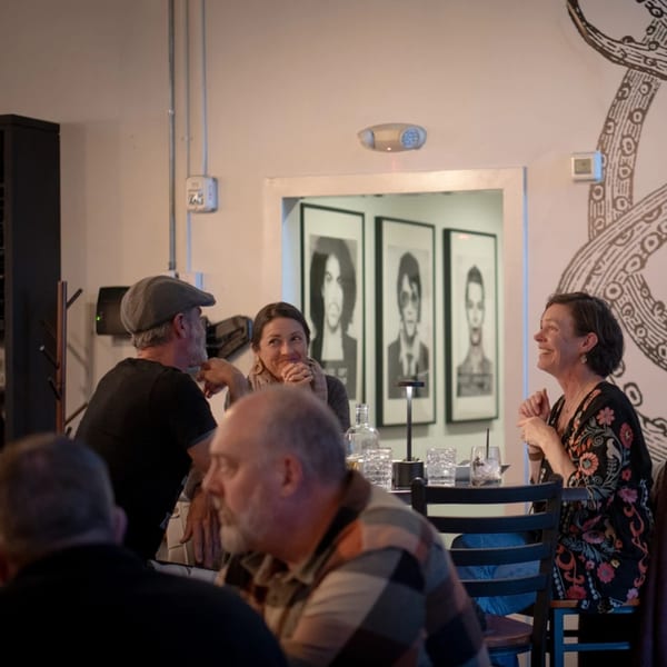 Patrons enjoying drinks and conversation at La Condesa Eatery, with unique artwork on the walls.